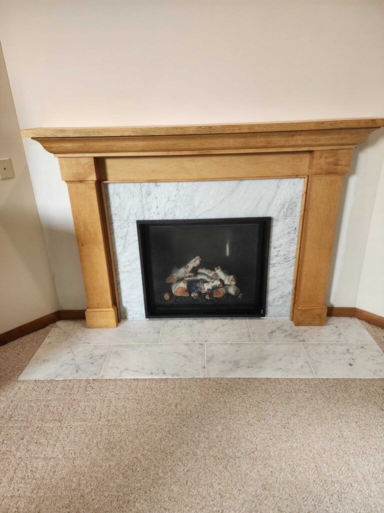 Gas fireplace insert with warm flames burning in stone surround